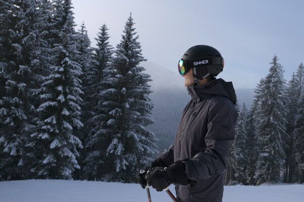 Sinner skihelm en skibril bij mistig weer. Gekleurede lens
